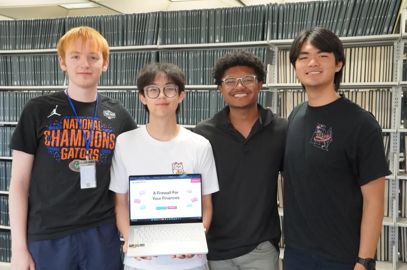 The four-person Subscriptos team at SASEHacks 2026 with the app on a laptop.